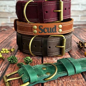 May include: Three leather dog collars in different colors and sizes. The top collar is burgundy, the middle collar is brown with the name "Scud" embossed on it, and the bottom collar is green.