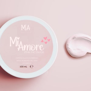 May include: A pink jar of face mask with the text "MiAmore Pink Facemask" and "Gentle clays combined with almond oil and vitamin E 100 mL e". A small pink swirl of the face mask is shown to the right of the jar.