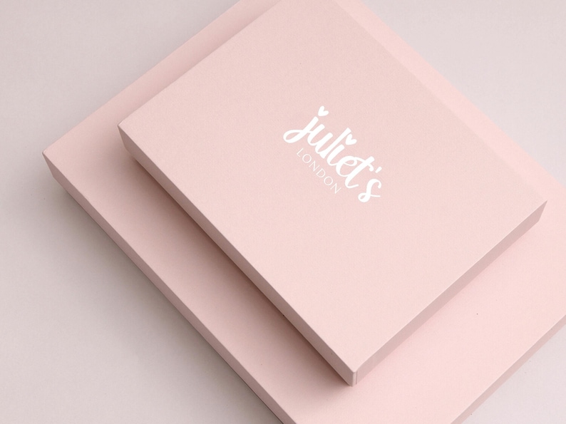 May include: Two pale pink boxes stacked on top of each other. The top box has the text "juliet's LONDON" printed in white.