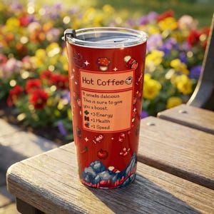 Puede incluir: Un vaso t&eacute;rmico rojo con tapa negra, con el texto "Hot Coffee" y gr&aacute;ficos pixelados. El vaso tiene una etiqueta que dice "It smells delicious. This is sure to give you a boost. +3 Energy, +1 Health, +1 Speed."