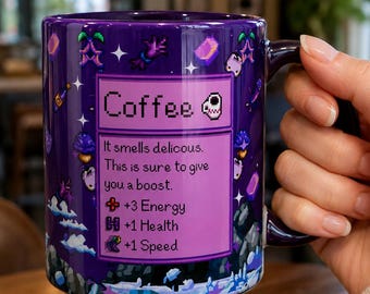 Puede incluir: Una taza de cerámica morada con un diseño de pixel art de una caja de objetos de juego etiquetada como Coffee. El texto dice: It smells delicous. This is sure to give you a boost. +3 Energy, +1 Health, +1 Speed. El fondo muestra varios iconos.