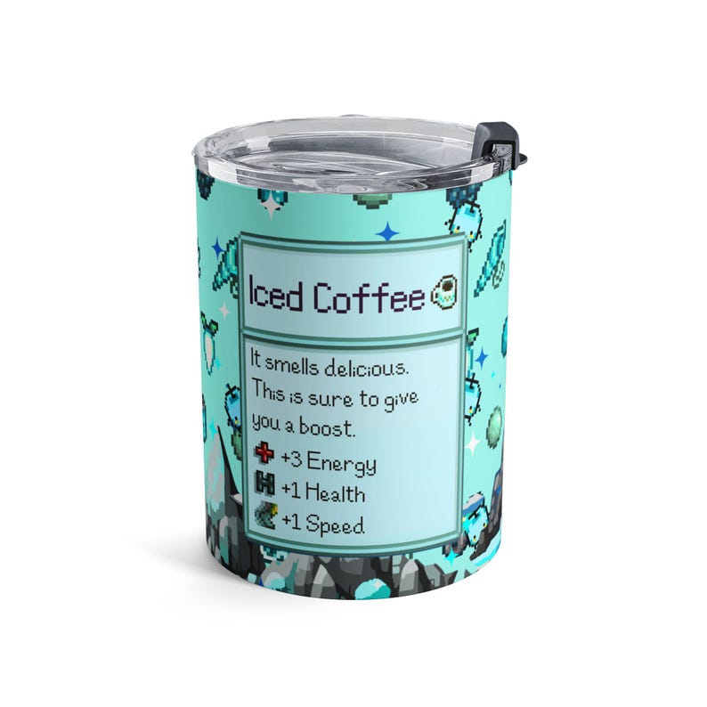 Puede incluir: Un termo de viaje turquesa con tapa y asa negras. El termo presenta un dise&ntilde;o pixelado con las palabras "Iced Coffee" y una descripci&oacute;n de sus beneficios, incluyendo +3 Energ&iacute;a, +1 Salud y +1 Velocidad.
