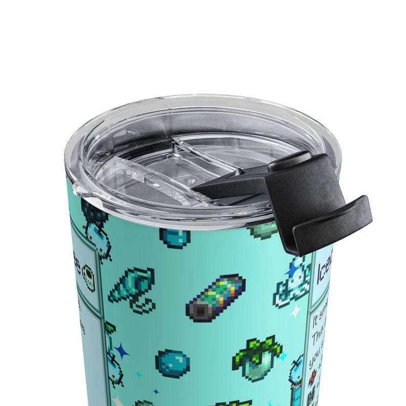 Puede incluir: Un vaso de viaje turquesa con tapa y asa negras. El vaso est&aacute; decorado con gr&aacute;ficos pixelados de varios objetos y texto. La tapa es transparente y el asa es negra.