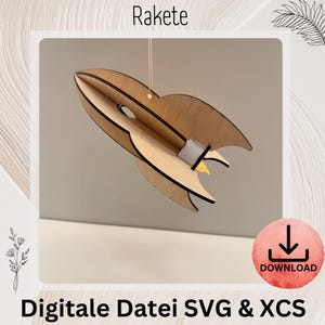 Könnte beinhalten: Ein Holzraketenmodell mit hellbraunem Finish, an einer Schnur aufgehängt. Die Rakete hat ein detailliertes Design mit Flossen und einer gelben Flamme. Das Wort "Rakete" steht oben und "Digitale Datei SVG & XCS" unten.