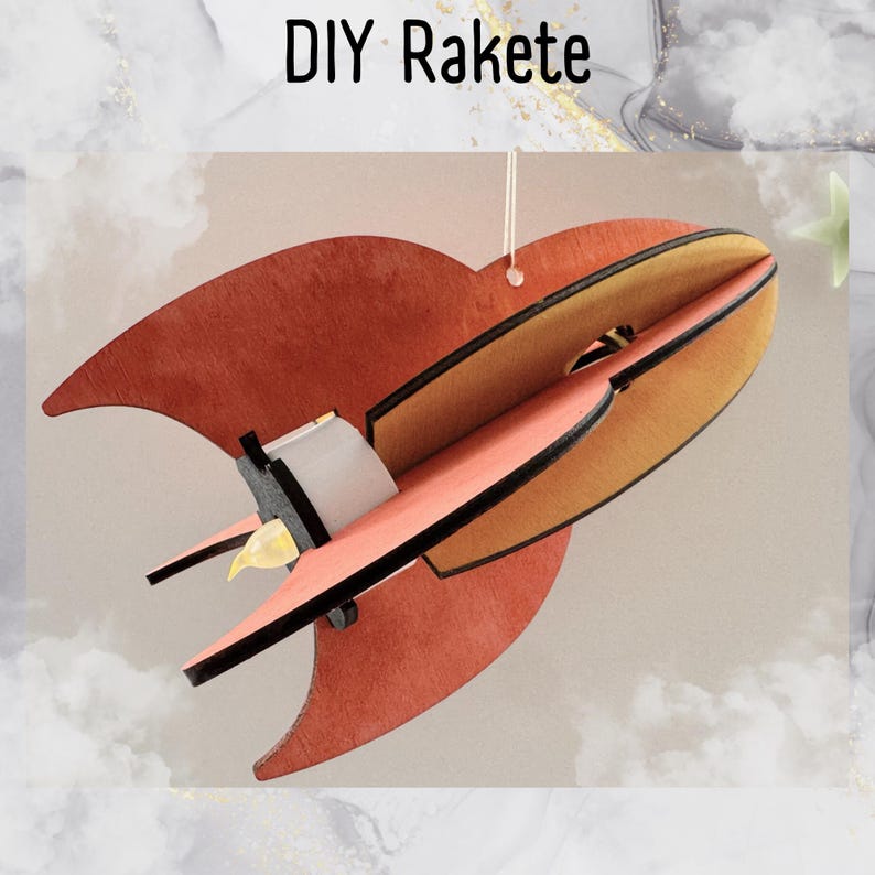 Może przedstawiać: Rakiety DIY z drewna, pomalowane w odcieniach pomarańczowego i ż&oacute;łtego. Rakieta ma czarny kontur i małe światło z tyłu.