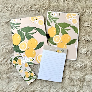 May include: A set of three lemon-themed stationery items: a notebook with a lemon and leaf design, a notepad with the words "Things to do" and a bookmark with the text "When life gives you lemons".