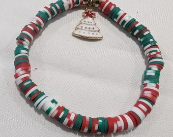 May include: A red, white and green Christmas themed bracelet with a gold charm of a Christmas tree.