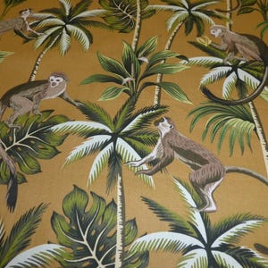 May include: A fabric pattern featuring monkeys and palm trees in shades of brown, green, and white against a golden background. The design includes detailed illustrations of monkeys among lush tropical foliage.