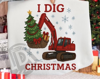 Puede incluir: Sudadera blanca con un diseño navideño. El diseño presenta una excavadora roja con un árbol de Navidad en su cucharón, copos de nieve y el texto "I DIG CHRISTMAS" en rojo. Una estrella dorada adorna el árbol.