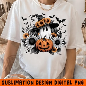 K&ouml;nnte beinhalten: Wei&szlig;es T-Shirt mit einem Sublimationsdesign, das einen Geist mit Hexenhut, einen K&uuml;rbis und schwarze Flederm&auml;use zeigt. Das Design ist von Sonnenblumen und Bl&auml;ttern umgeben.