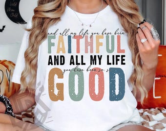 May include: White t-shirt with a colorful graphic design that reads "And all my life you have been faithful and all my life you have been so good".