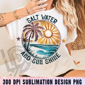 May include: White t-shirt with a graphic design of a palm tree, sun, and ocean waves. The text "Salt Water and Sun Shine" is written in a vintage font.