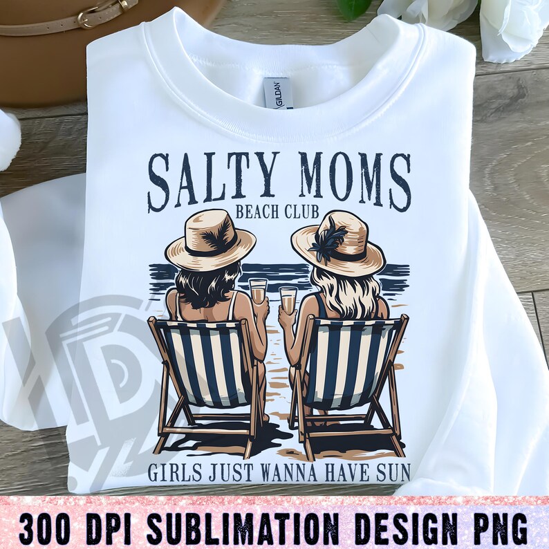 Op de afbeelding: Een wit sublimatieontwerp met twee vrouwen die hoeden en zonnebrillen dragen en op strandstoelen zitten met drankjes in hun handen. De tekst luidt "Salty Moms Beach Club Girls Just Wanna Have Sun".