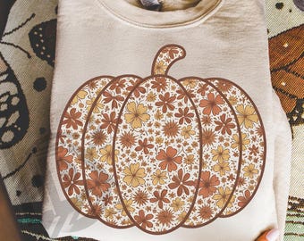 Op de afbeelding: Een beige sweatshirt met een groot pompoenontwerp. De pompoen is gevuld met een bloemenpatroon in bruin-, oranje- en geeltinten. De tekst "300 DPI SUBLIMATION DESIGN PNG" staat onderaan.