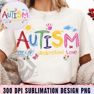 以下が含まれることがあります： 白いTシャツに、カラフルな手書きのデザインが施されています。「AUTISM accept understand love」と書いてあります。デザインは子供らしいスタイルで、太陽、雲、手形が描かれています。