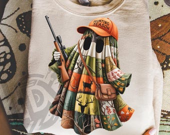 May include: A beige sweatshirt featuring a whimsical ghost character wearing an orange "Hunting Season" cap and carrying a rifle. The ghost's body is a patchwork of forest scenes, with a brown satchel. The text "300 DPI SUBLIMATION DESIGN PNG" is at the bottom.