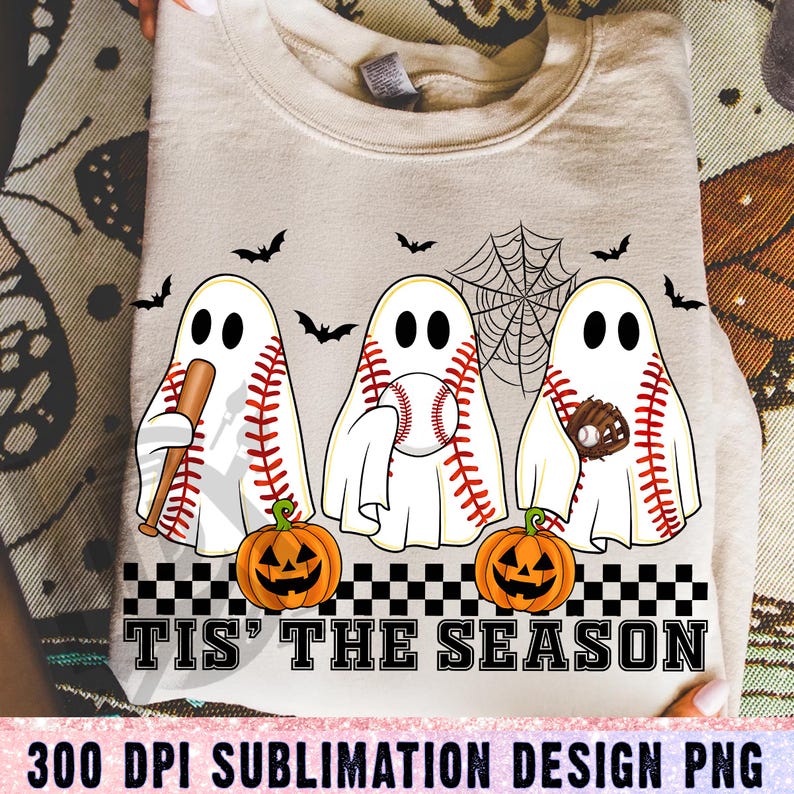 May include: Beige sweatshirt with a Halloween baseball theme. Features three ghost figures with baseballs, bats, and gloves, along with jack-o'-lanterns and bats. The text "TIS' THE SEASON" is displayed below the figures.