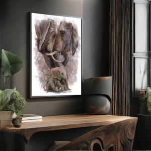 May include: A framed art print featuring a watercolor painting of an elephant family. The artwork depicts two adult elephants and a baby elephant in shades of brown, gray, and white. The print is displayed on a wooden table.
