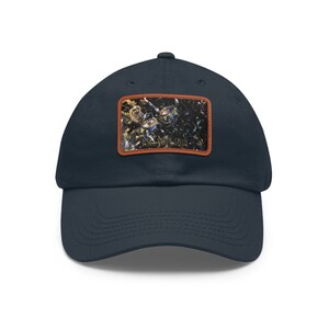 Könnte beinhalten: Eine marineblaue Baseballkappe mit einem braunen Lederpatch, der ein farbenfrohes abstraktes Design und den Text "LEGENDS ONLY" zeigt.
