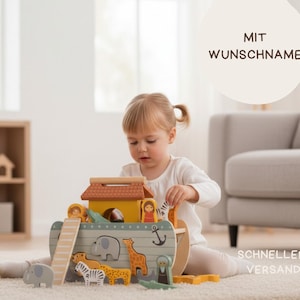May include: A wooden Noah's Ark toy with various animal figures and a small house on top. The ark is painted in pastel colors and includes a ramp. The text "MIT WUNSCHNAME" is visible in the background.