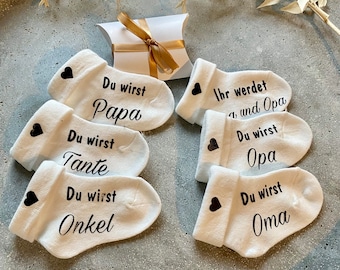Diventerai papà, annuncio di gravidanza, annuncio di un bambino, diventerai nonno e nonna, zio e zia. Calzino in una piccola scatola regalo. Annuncio di famiglia, papà.