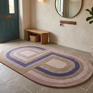 Entry foyer with two modern oval area rug pieces, lavender mauve palette and retro geometric arches