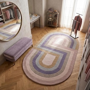 Dressing nook with round mirror and modern oval area rug, purple oval rug adds retro geometric warmth