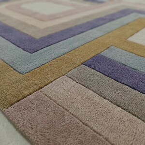 Macro view of carved relief texture, hand tufted wool pile in purple and beige, modern oval area rug detail