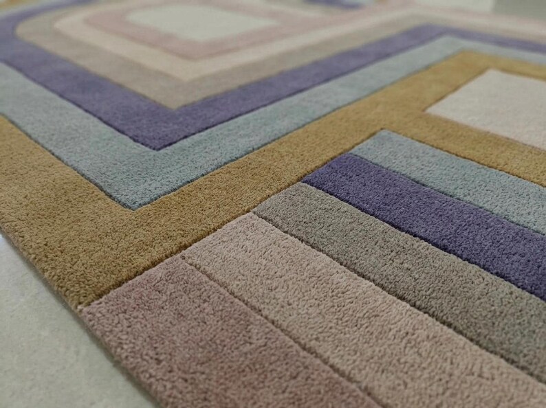 Macro view of carved relief texture, hand tufted wool pile in purple and beige, modern oval area rug detail