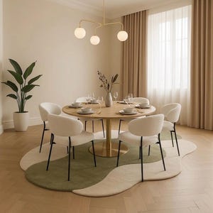 May include: A dining room set with a round wooden table, six white upholstered chairs, and a unique green and cream-colored rug. A gold chandelier hangs above the table, and a large potted plant is in the corner.