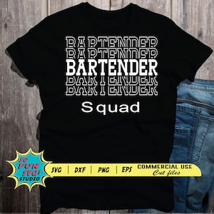 May include: Black t-shirt with white text that reads "BARTENDER" repeated four times and "Squad" below. The shirt is on a wooden surface with a pair of blue jeans.