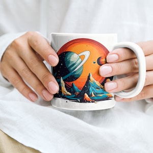 以下が含まれることがあります： リング、山、太陽のある惑星がカラフルに描かれた白いセラミックマグカップ。イラストはレトロなスタイルです。