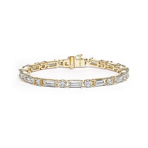 Op de afbeelding: Een gouden armband met een reeks afwisselende rechthoekige en rond geslepen heldere edelstenen. De armband heeft een sluiting en is geplaatst tegen een witte achtergrond. De sieraden zijn waarschijnlijk van goud.