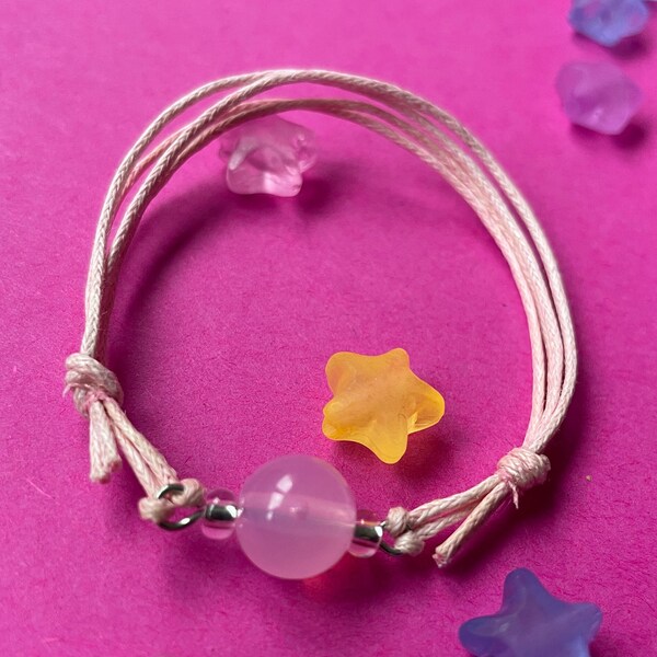 Douceur Rose - Bracelet en perle plastique et rocailles. Réglable par les deux nœuds coulissants.