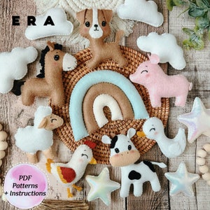 Könnte beinhalten: Ein Set aus Filztier- und Wolkenformen, darunter ein Pferd, ein Schwein, eine Kuh, ein Hund, ein Huhn, ein Lamm und ein Regenbogen, vor weißem Hintergrund. Der Text "ERA" ist in der oberen linken Ecke des Bildes sichtbar.
