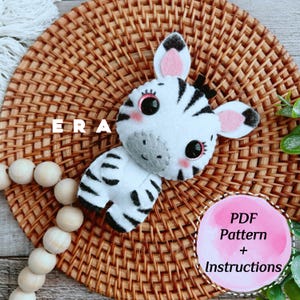 May include: A handmade felt zebra toy with black and white stripes, pink inner ears, and large black eyes. The word "ERA" is visible. A pink circle with the text "PDF Pattern + Instructions" is also present. The zebra is on a woven surface.