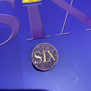 Badge Six the Musical à paillettes violettes avec logo - Accessoire royal pour les fans
