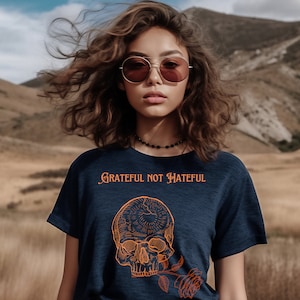 May include: A navy blue t-shirt with a graphic of a skull with a rose. The text "Grateful Not Hateful" is printed on the shirt.