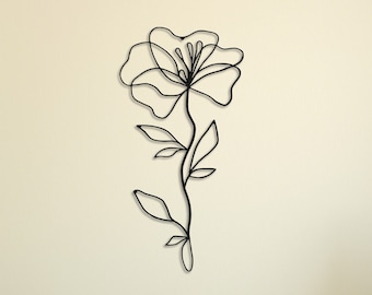 May include: Black metal wall decor featuring a stylized line drawing of a flower with a long stem and leaves.