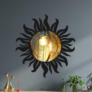 May include: A black sunburst mirror with a gold-toned reflective surface hangs above a wooden dresser with drawers and shelves. The dresser is in a room with a light blue wall and plants.