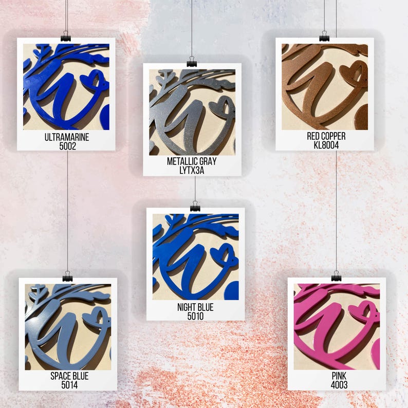 Puede incluir: Primer plano de seis opciones de color diferentes para un letrero de decoraci&oacute;n para el hogar de metal. El letrero presenta la palabra "hogar" con un dise&ntilde;o floral estilizado. Los colores son azul ultramar, gris met&aacute;lico, cobre rojo, azul espacial, azul noche y rosa.