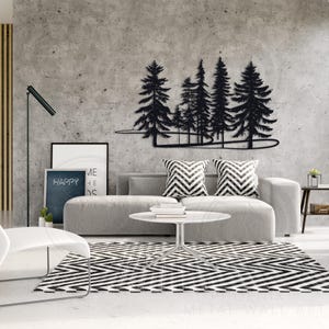 May include: Black metal wall art depicting a forest scene with trees and a winding path. The art is mounted on a gray concrete wall above a gray couch with black and white patterned pillows.