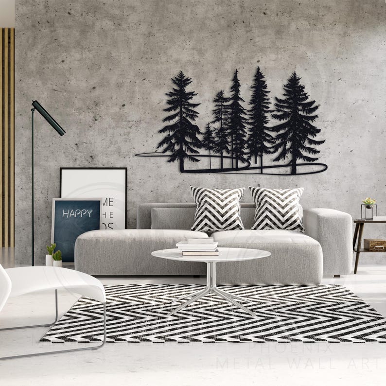 May include: Black metal wall art depicting a forest scene with trees and a winding path. The art is mounted on a gray concrete wall above a gray couch with black and white patterned pillows.