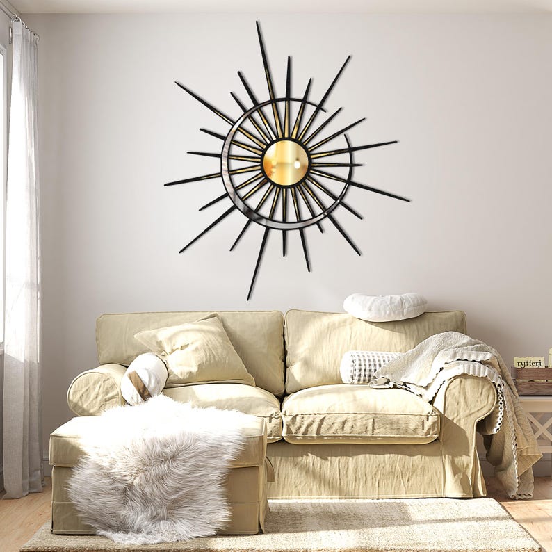 Puede incluir: Un sof&aacute; beige con una manta blanca y una alfombra de piel sint&eacute;tica blanca delante. Una decoraci&oacute;n de pared de metal negro en forma de sol con un espejo dorado en el centro est&aacute; colgada en la pared detr&aacute;s del sof&aacute;.