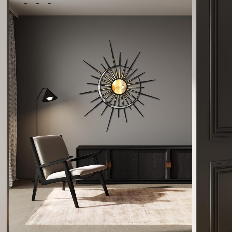 Puede incluir: Una decoraci&oacute;n de pared de sol de metal negro con un espejo dorado en el centro. La decoraci&oacute;n est&aacute; colgada en una pared gris en un sal&oacute;n.