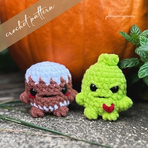 May include: Two crocheted amigurumi toys, one brown with white frosting and the other green with a red heart, are sitting on a brown surface. The text "crochet pattern" is in the background.