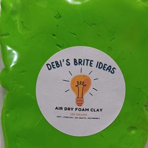May include: A green air dry foam clay in a clear plastic bag. The bag has a white label with the text "DEBI'S BRITE IDEAS" and a lightbulb graphic. The label also says "AIR DRY FOAM CLAY", "100 GRAMS", "SOFT - STRETCHY - DIY CRAFTS - KID FRIENDLY".