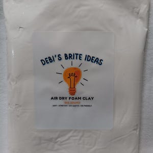 May include: A white bag of air dry foam clay with a label that says "DEBI'S BRITE IDEAS" and a lightbulb graphic. The label also says "AIR DRY FOAM CLAY 500 GRAMS SOFT - STRETCHY - DIY CRAFTS - KID FRIENDLY".