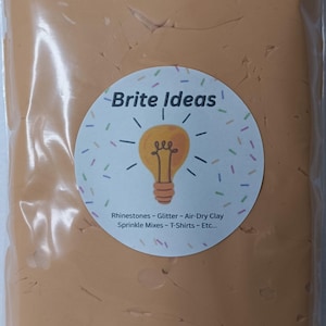 May include: A package of light brown air-dry clay. The package has a circular sticker with the words "Brite Ideas" and a lightbulb illustration. The sticker also lists rhinestones, glitter, sprinkle mixes, and T-shirts.