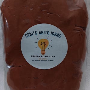 May include: A package of brown air dry foam clay. The label reads "DEBI'S BRITE IDEAS" with a lightbulb illustration. It also states "AIR DRY FOAM CLAY 100 GRAMS SOFT - STRETCHY - DIY CRAFTS - KID FRIENDLY".